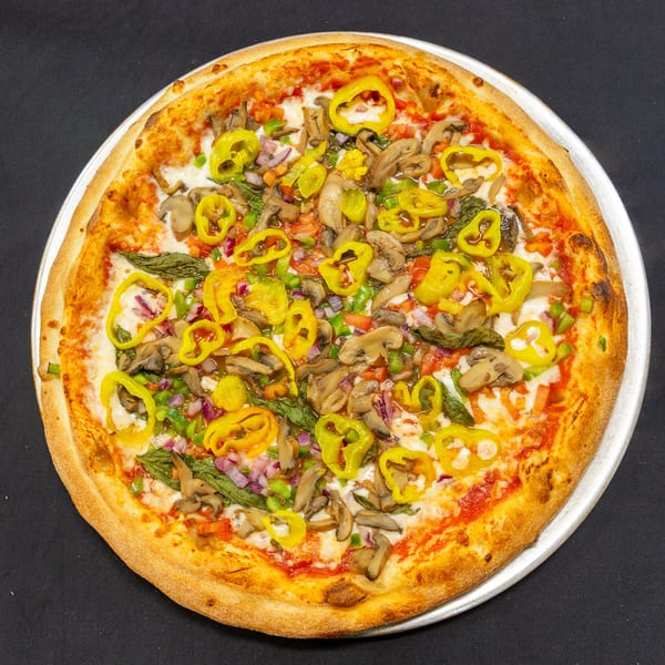A vibrant veggie pizza with mushrooms, peppers, onions, and basil on a dark background.
